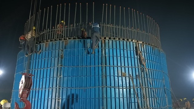Large cylindrical concrete structure construction at night
